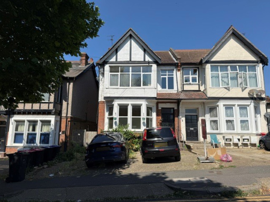 Lot: 180 - VACANT FIRST FLOOR FLAT FOR IMPROVEMENT - General view of the building with residents parking area to front